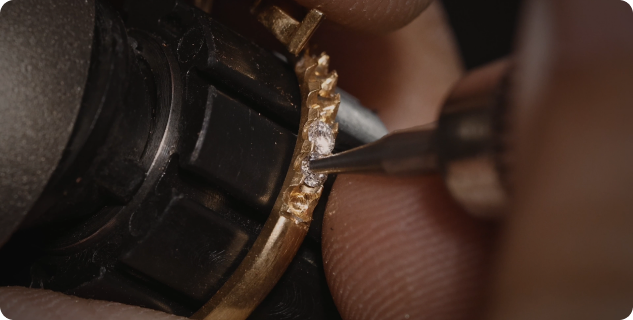 Close-up of a diamond being set by hand