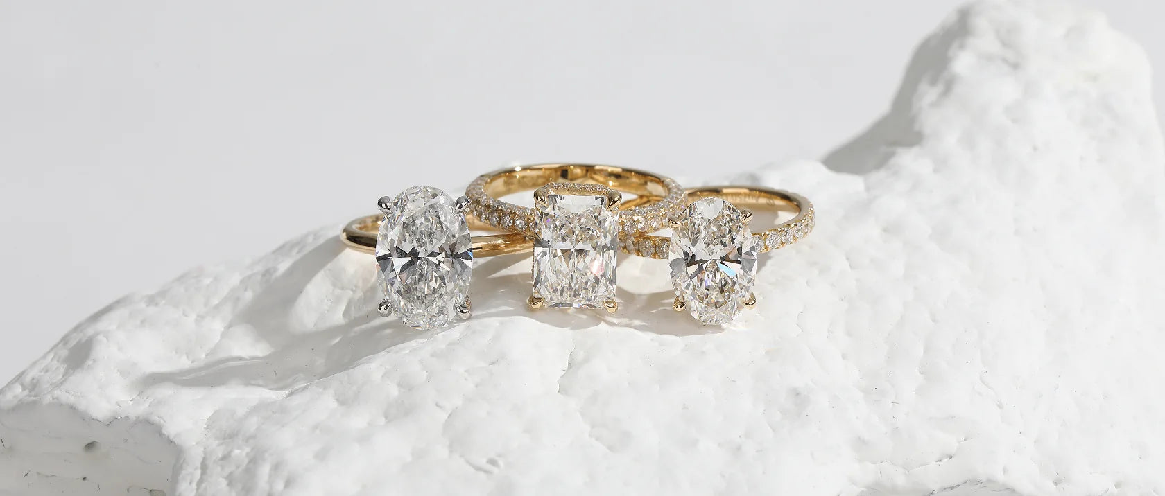 Three lab-grown diamond engagement rings in yellow gold